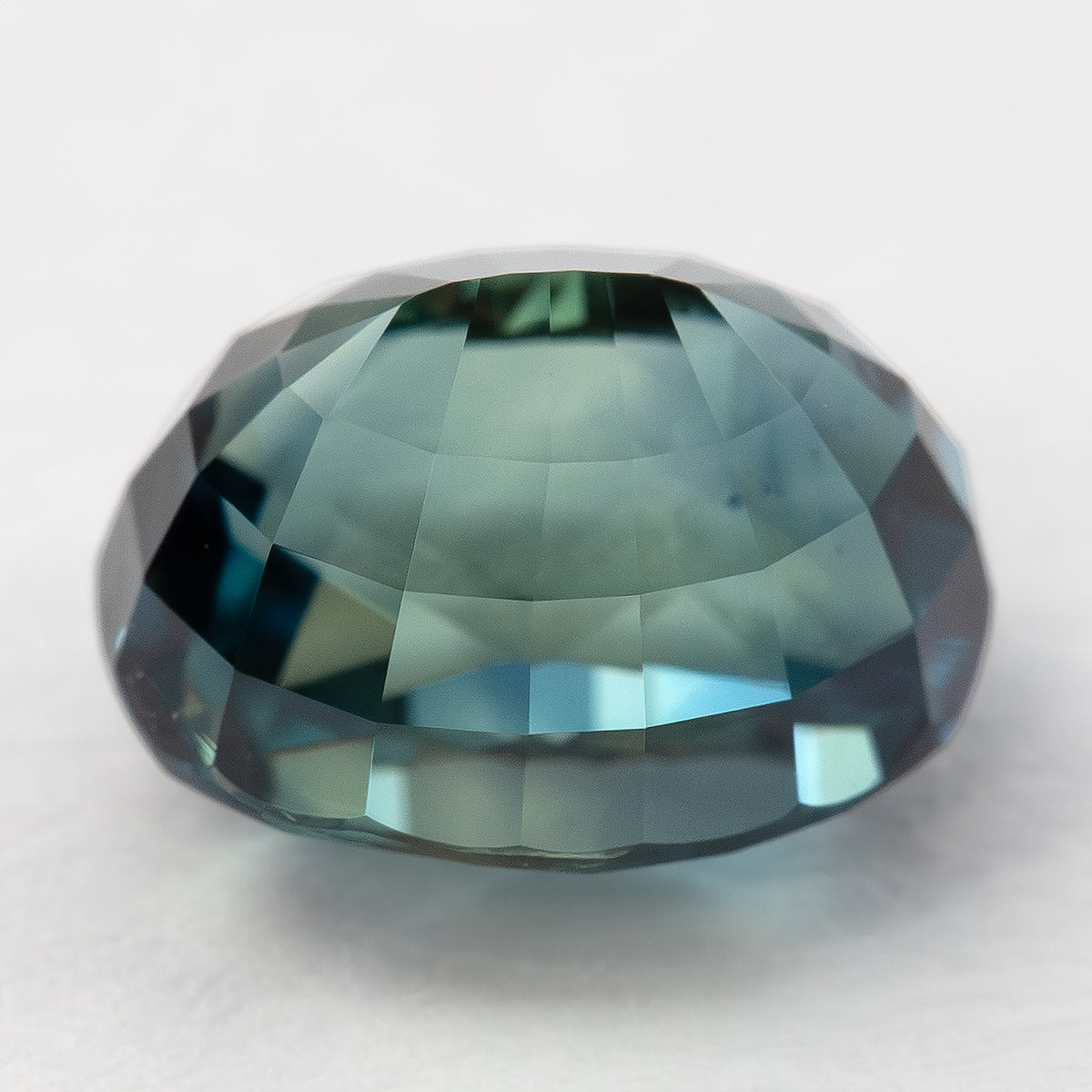 Side view of the oval sapphire showing pavilion step facets and girdle.
