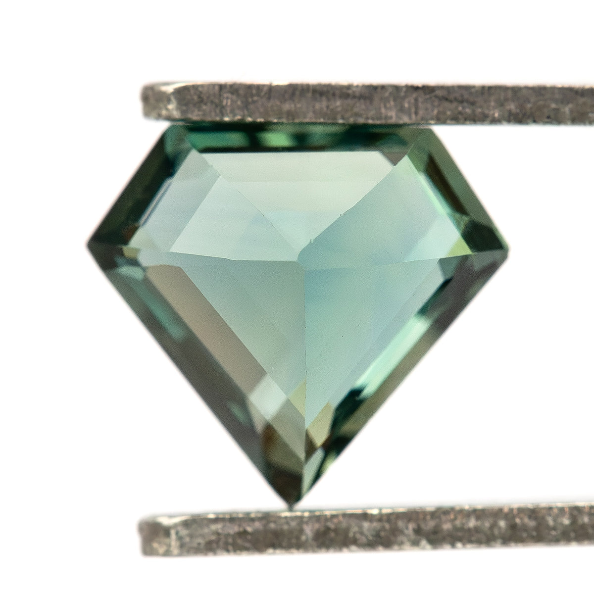 Pavilion view of the exact sapphire held in tweezers, showing the back facet arrangement.