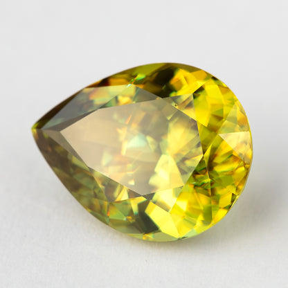 Pear-shaped sphene tilted on white with a broad pale reflection through the table.