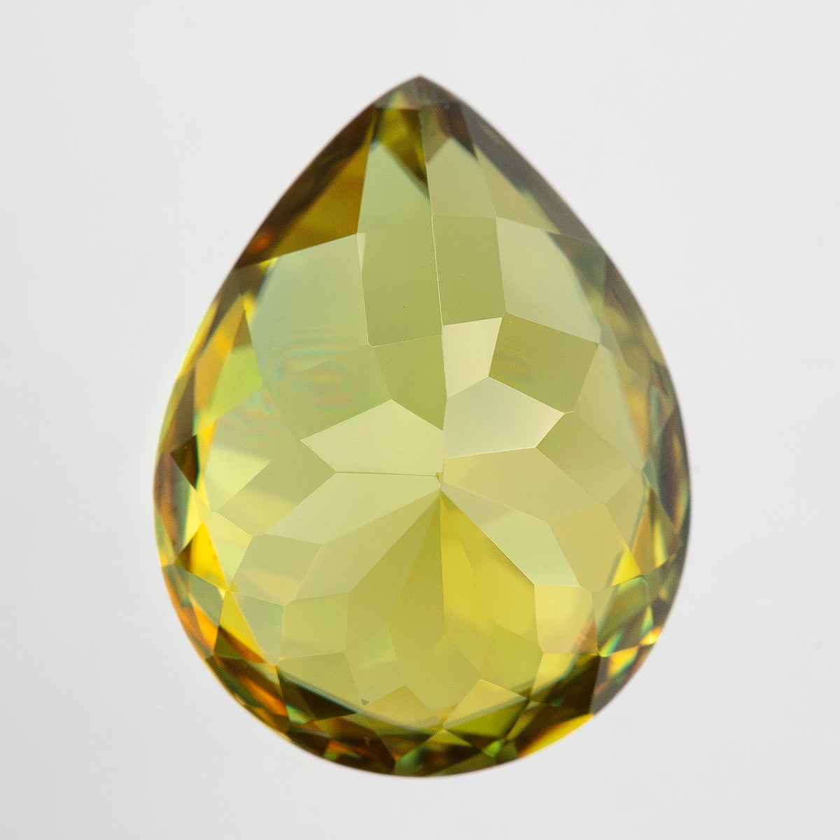 Upright pavilion-side view of the pear-shaped sphene on white, with broad yellow-green facets.