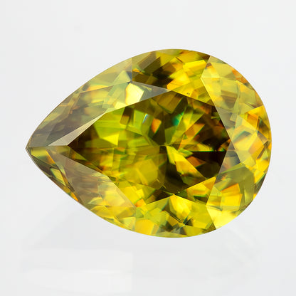 Close face-up view of the pear-shaped sphene on white, with golden-yellow reflections around a darker centre.