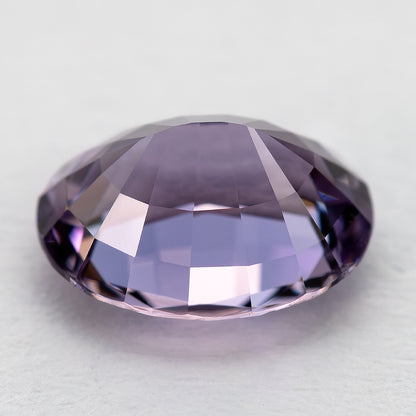 Oblique reverse view of spinel showing the pavilion above a pale surface.