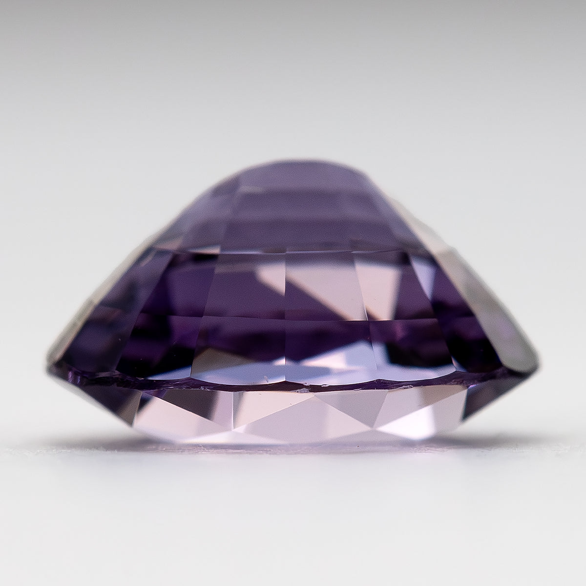 Angled side view of spinel showing pavilion facets and depth.