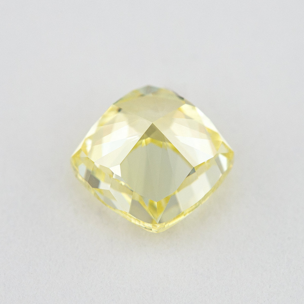 Pavilion and back view of the cushion-shaped yellow diamond, showing broad rear facets and its outline.
