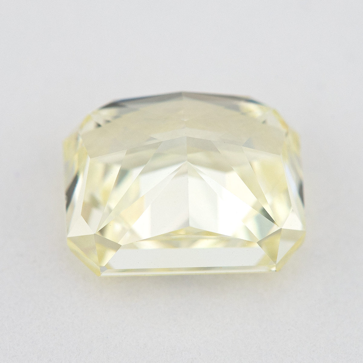 Low side view of the pale yellow rectangular radiant-cut natural diamond, showing the crown, girdle and pavilion facets.