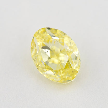 Upright face-up view of the oval yellow diamond, with brilliant facets and a dark inclusion cluster.