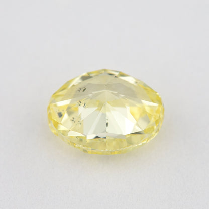 Back and pavilion view of the oval yellow diamond, with inclusions visible through broad facets.