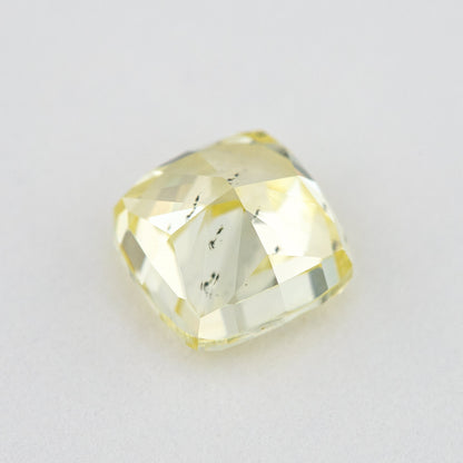 Pavilion and back view of the cushion-shaped yellow diamond, with broad rear facets and dark marks visible within the stone.