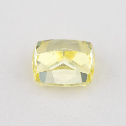 Low tilted view of the yellow cushion diamond, showing broad pavilion facets and the depth below its crown.