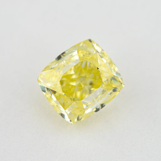 Face-up cushion-shaped yellow diamond on a pale background, showing the complete outline and broad table.