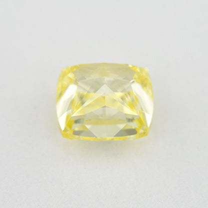 Back and pavilion view of the cushion-shaped yellow diamond on a pale background.