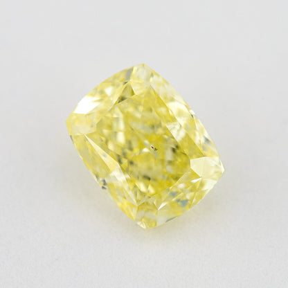 Angled crown view of the elongated cushion-shaped yellow diamond, showing its rectangular outline and reflected facet pattern.