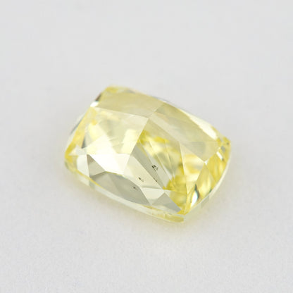 Pavilion and back view of the elongated cushion-shaped yellow diamond, showing broad rear facets and dark marks.