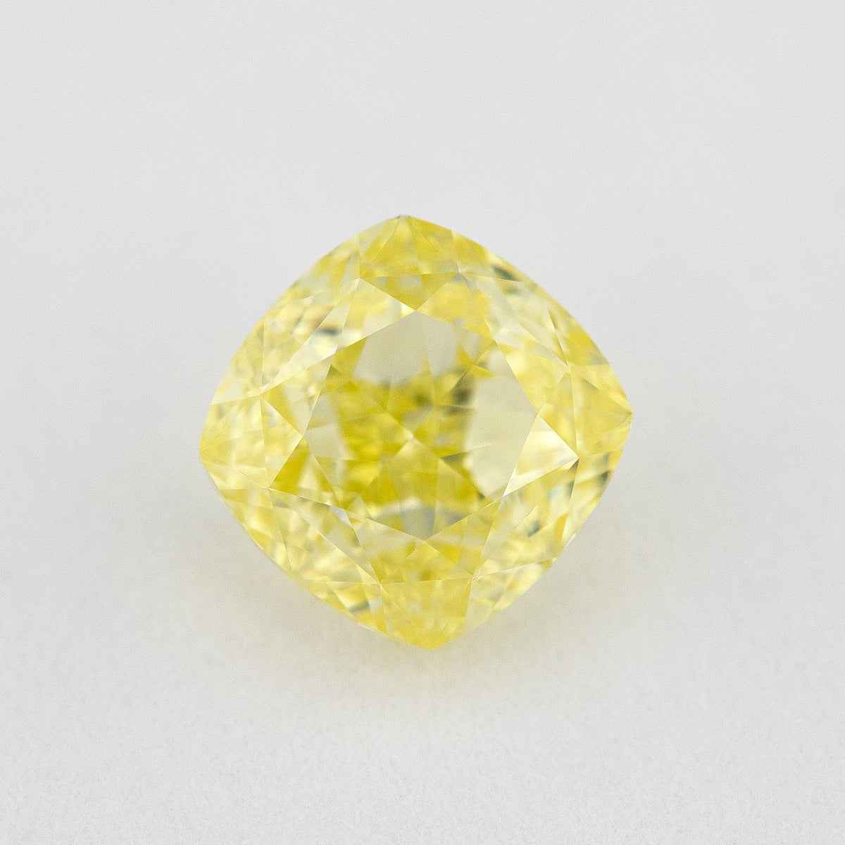 Face-up view of the yellow cushion diamond, showing its complete outline, table and crown facet reflections.