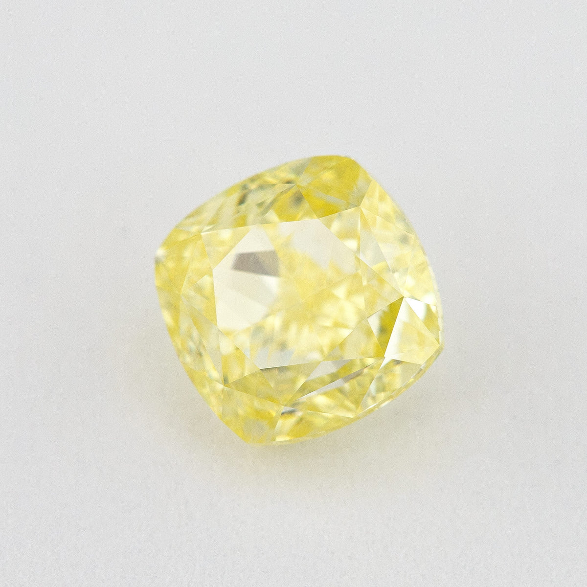 Alternate crown-side view of the yellow cushion diamond, showing its table and facet reflections.