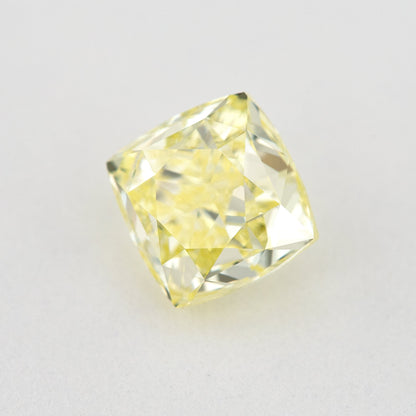 Angled crown view of the cushion-shaped yellow diamond, with broad bright facets and a lighter reflected pattern.