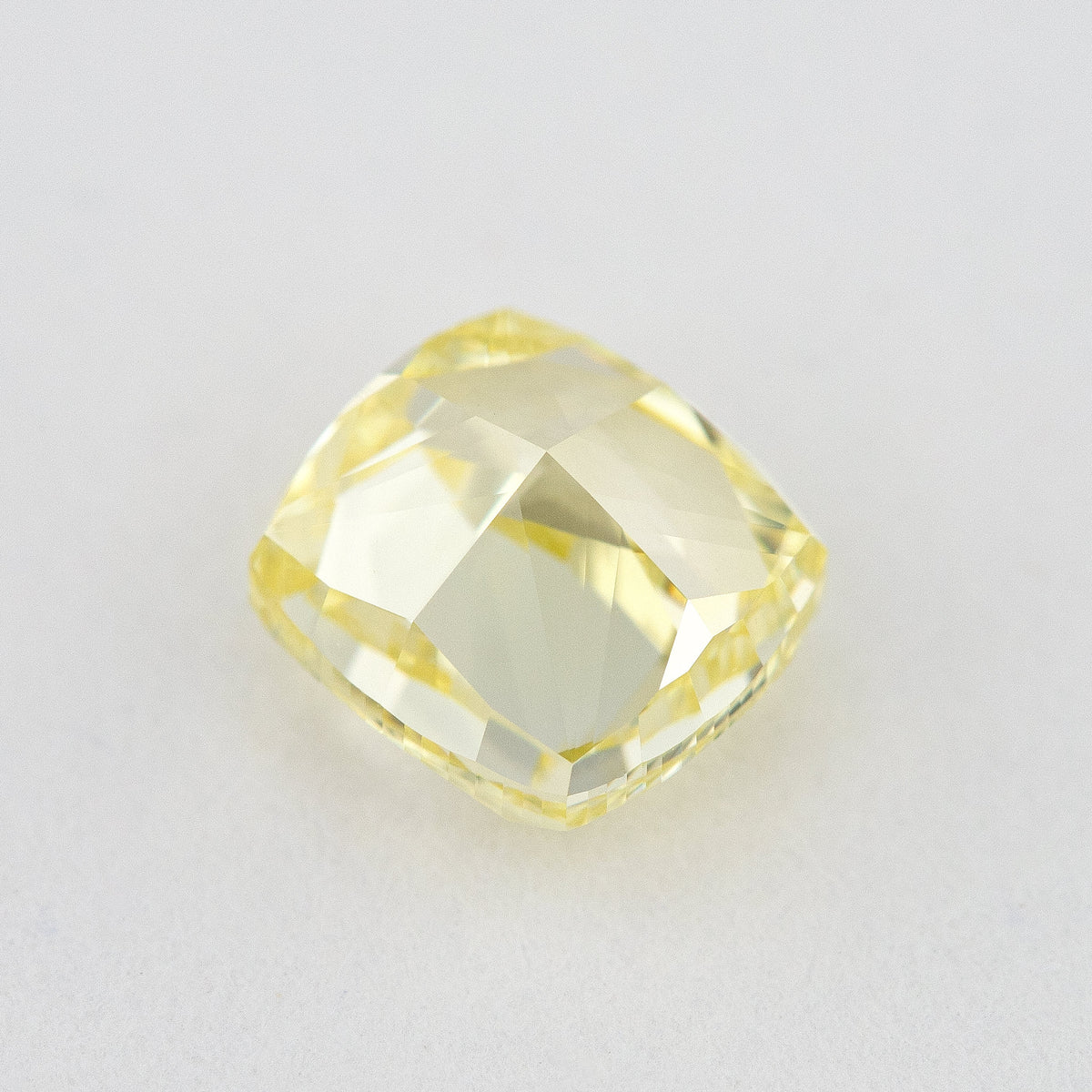 Pavilion and back view of the cushion-shaped yellow diamond, showing broad rear facets and its outline.