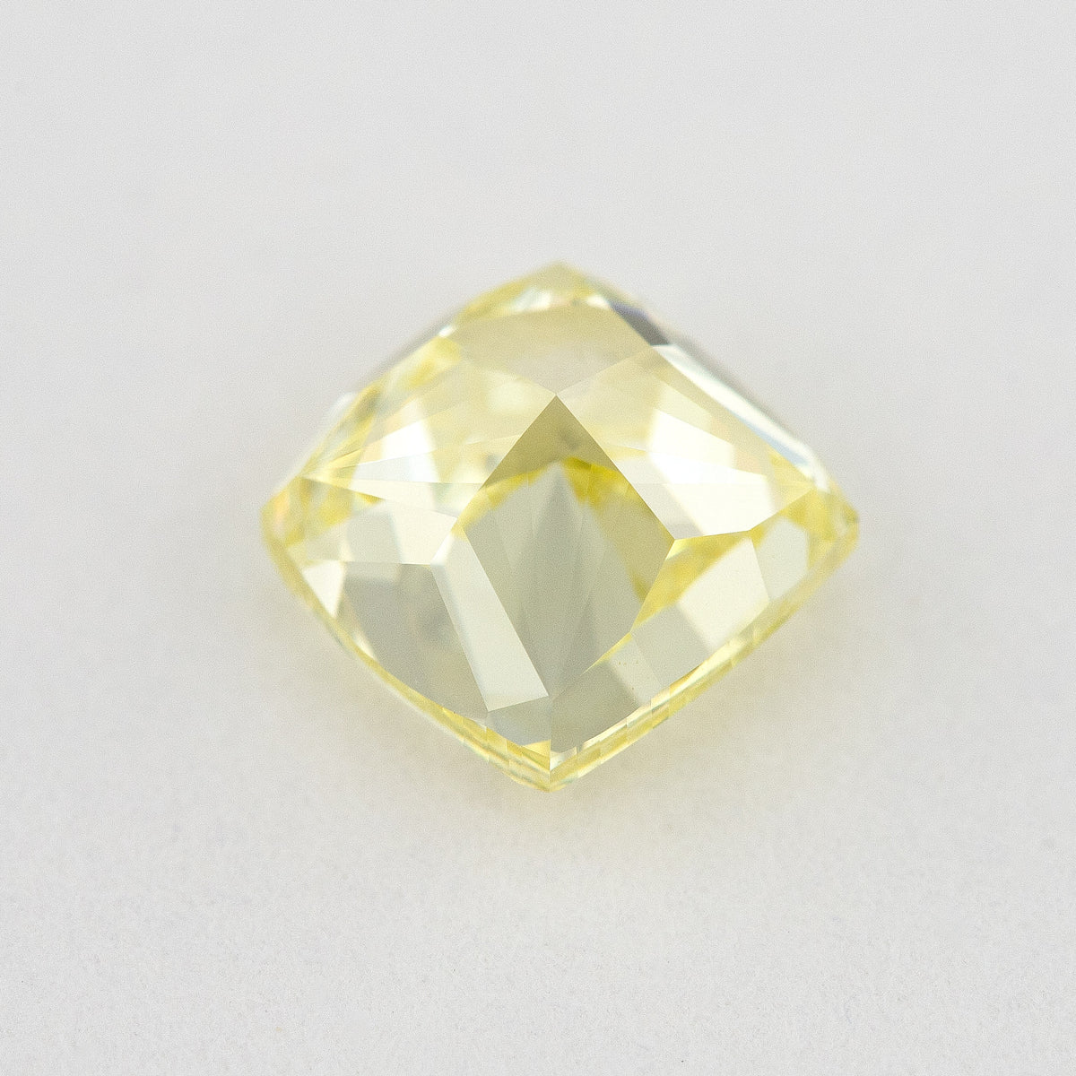 Pavilion and back view of the cushion-shaped yellow diamond, showing broad rear facets and its outline.