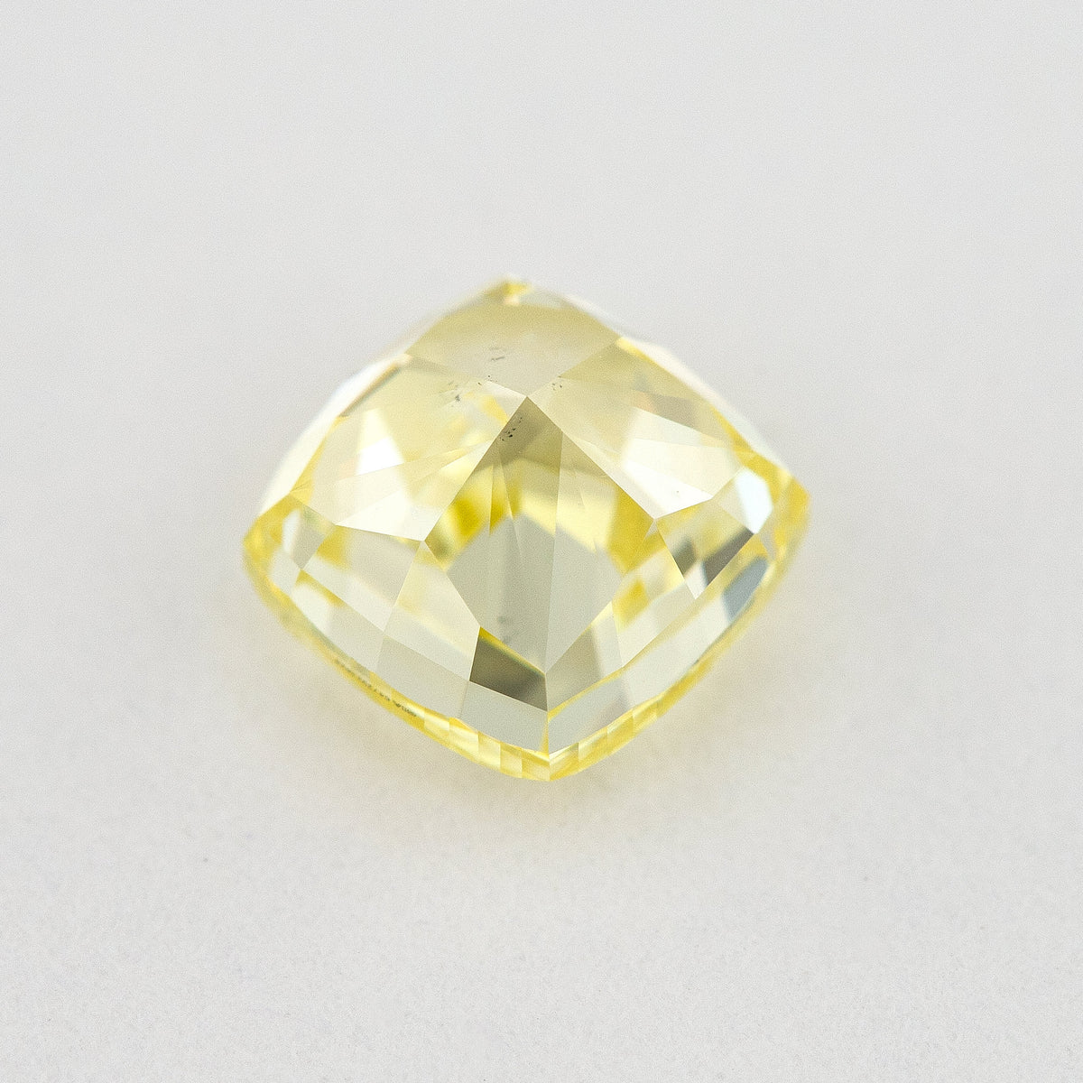Pavilion and back view of the cushion-shaped yellow diamond, showing broad rear facets and its outline.