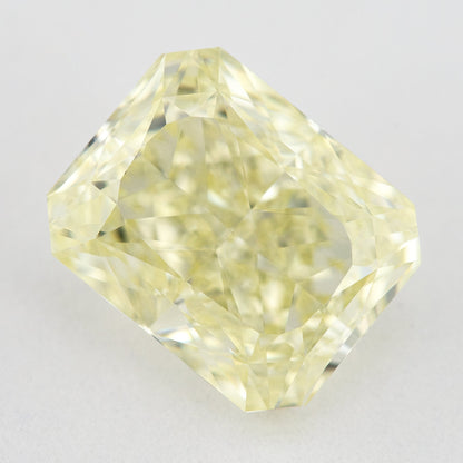 Face-up view of a pale yellow rectangular radiant-cut natural diamond on a pale surface, showing its complete outline and crown facets.