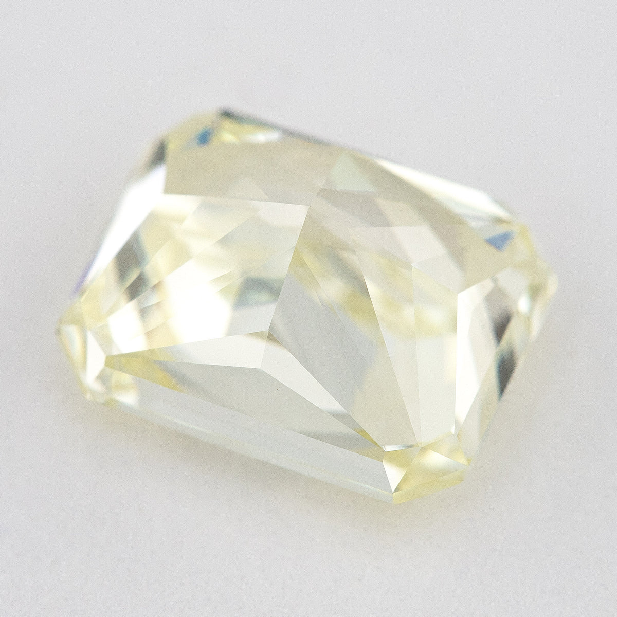 Low side view of the pale yellow rectangular radiant-cut natural diamond, showing the crown, girdle and pavilion facets.