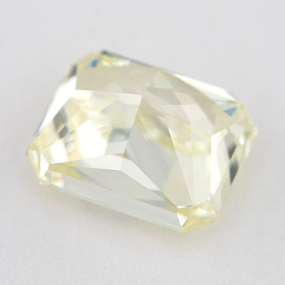 Low side view of the pale yellow rectangular radiant-cut natural diamond, showing the crown, girdle and pavilion facets.