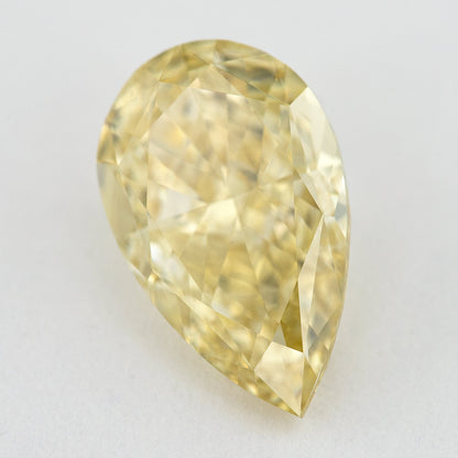 Alternate angled face-up view of the yellow pear diamond on a pale background, with a different pattern of light and dark facet reflections.