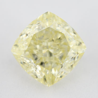 Face-up pale yellow cushion-shaped diamond on a light surface, showing its complete outline, table and crown facets.