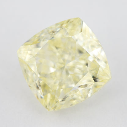 Angled crown view of the pale yellow cushion-shaped diamond, with broad bright facets and darker reflections.