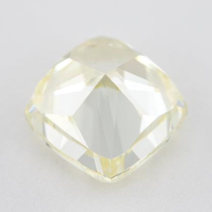 Pavilion and back view of the pale yellow cushion-shaped diamond, showing broad rear facets on a light surface.