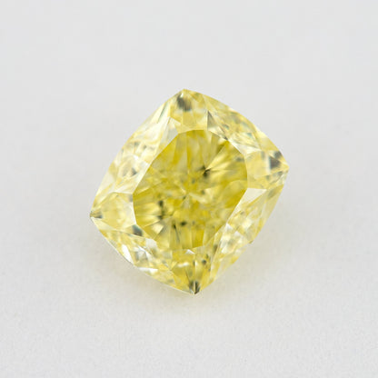 Face-up rectangular cushion-shaped yellow diamond on a pale background, showing yellow table reflections and bright facets.
