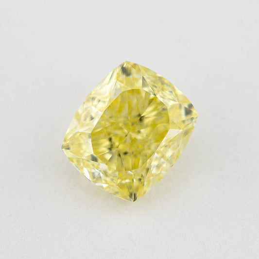 Face-up rectangular cushion-shaped yellow diamond on a pale background, showing yellow table reflections and bright facets.