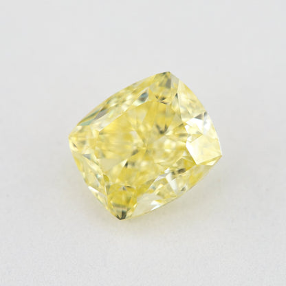Cushion-shaped yellow diamond rotated on a pale background, with lighter reflected facets visible.