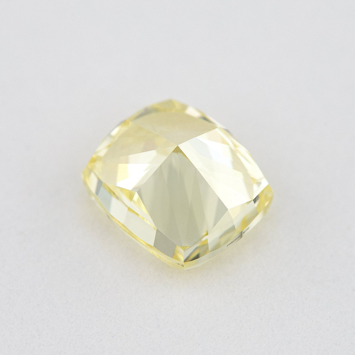 Back and pavilion view of the cushion-shaped yellow diamond, showing broad facets and the girdle.