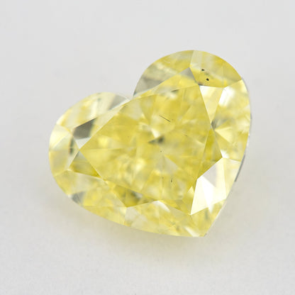 Tilted crown view of the yellow heart-shaped natural diamond, showing a different pattern of bright and dark facet reflections.