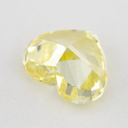 Low side view of the yellow heart-shaped natural diamond, showing the crown, girdle and pavilion facets.