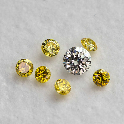 Yellow diamonds at mixed face-up and tilted angles around a white comparison diamond, not included.
