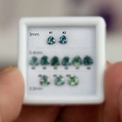 Numbered 3.0 mm natural teal trillion sapphires #1 and #2, shown face-up for exact-stone selection.
