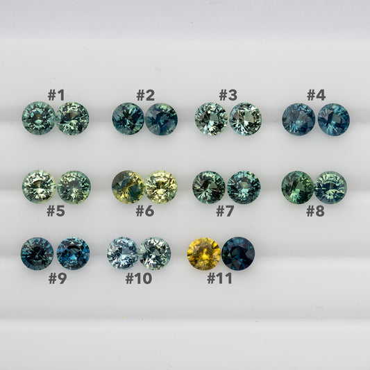 Close face-up overview of eleven numbered sapphire pairs in teal, blue, green and yellow tones.