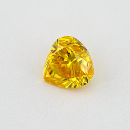 Different face-up angle of the yellow-orange heart-shaped diamond showing its table and crown facet reflections.