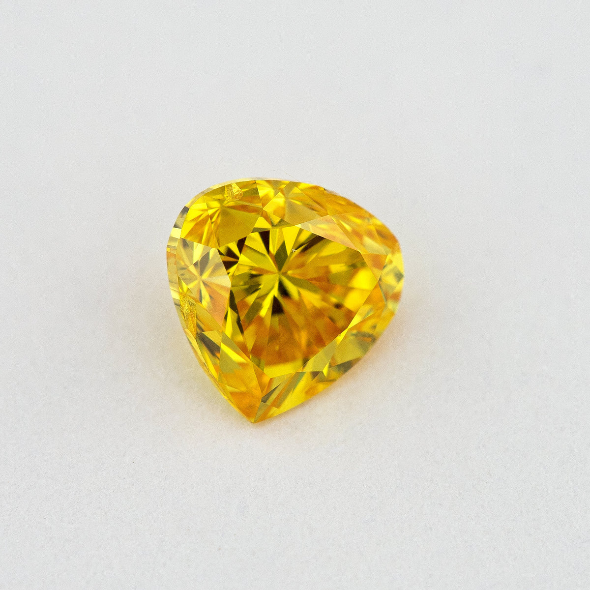 Face-up view of the yellow-orange heart-shaped diamond, showing its complete outline and crown facet reflections.
