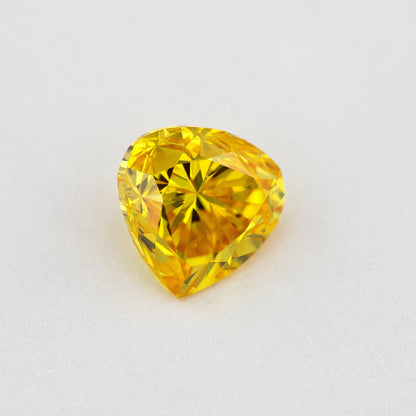 Face-up view of the yellow-orange heart-shaped diamond, showing its complete outline and crown facet reflections.