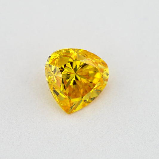 Face-up view of the yellow-orange heart-shaped diamond, showing its complete outline and crown facet reflections.