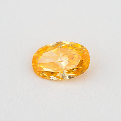 Angled crown view of the oval orange diamond, with broad bright facets and lighter yellow reflections.