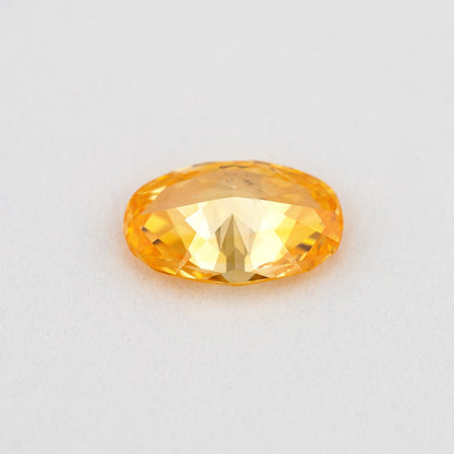 Pavilion and back view of the oval orange diamond, showing its rear facets and elongated outline.