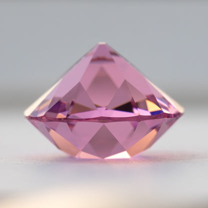 Pink cushion-shaped lab-grown YAG viewed from the side, showing crown and pavilion depth. View 10.