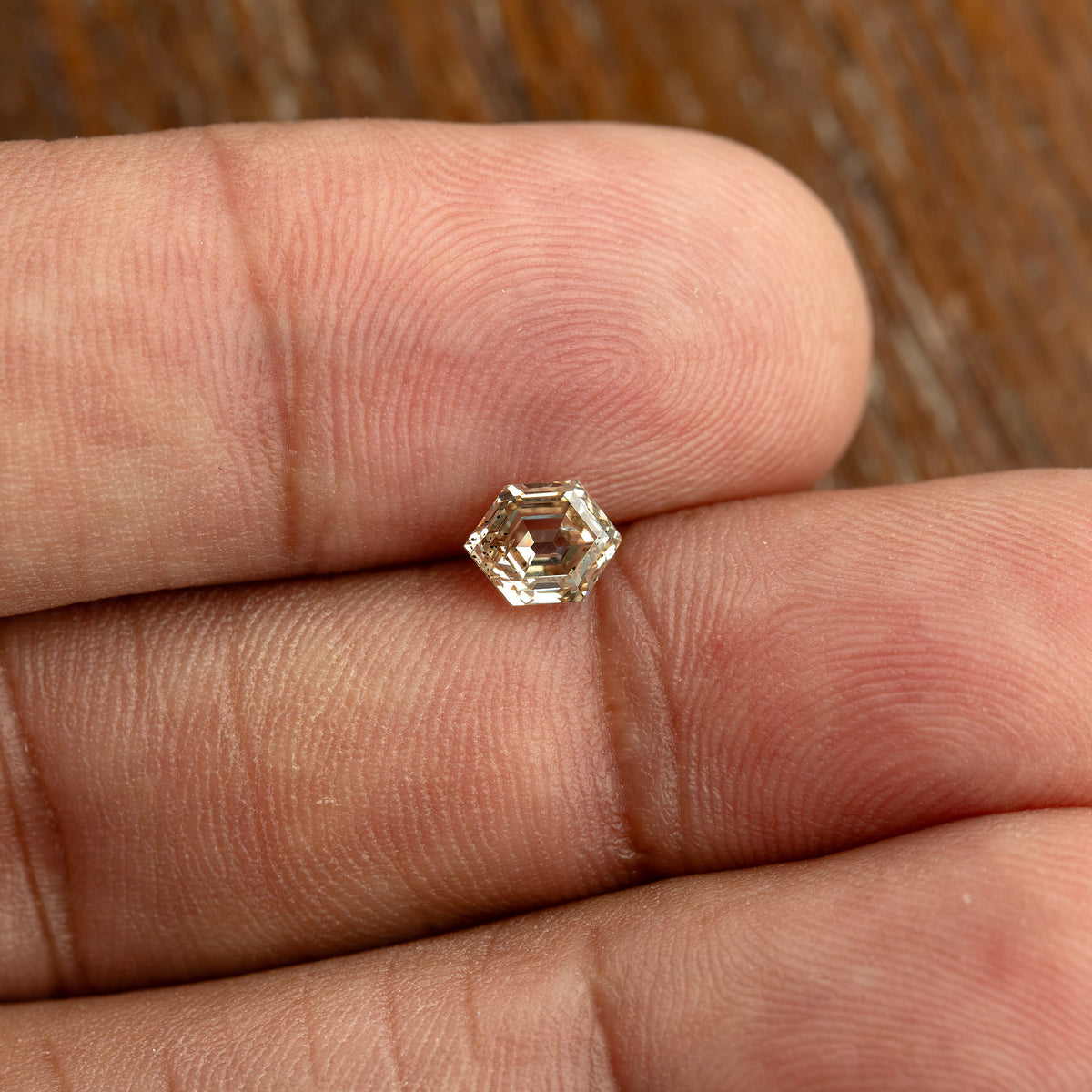 Wide hand-scale view of the 0.68 ct natural champagne diamond