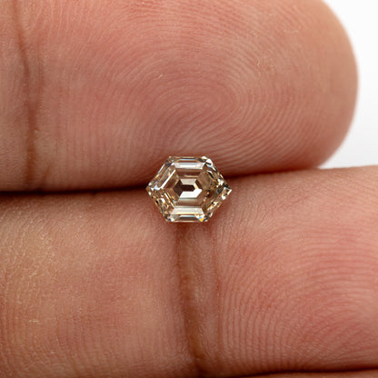 Hand-scale close-up showing the diamond's warm brownish yellow appearance