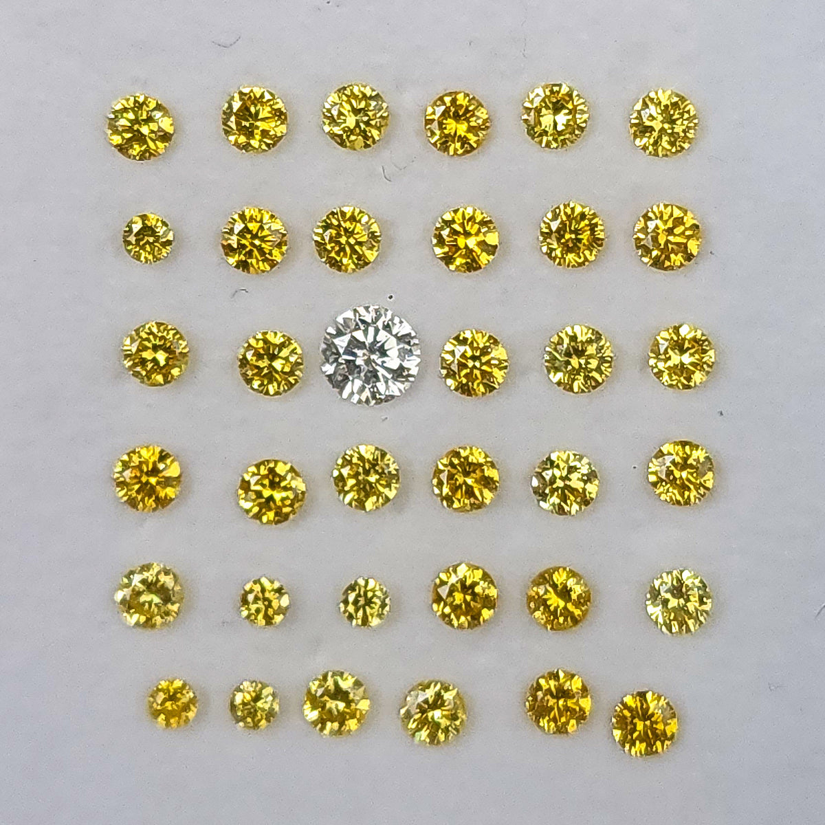 Rows of yellow diamonds with a white comparison diamond, not included in the sale.