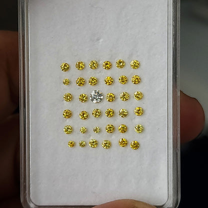 Yellow diamond display pad held against fingers, showing size context.